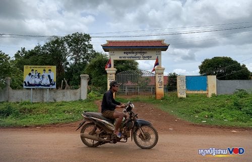 បុរសម្នាក់ជិះម៉ូតូកាត់ពីមុខសាលាបឋមសិក្សា​ស្រែ​ក្លេង ក្នុង​ភូមិ​ឡាំ​មេះ ឃុំ​ប៊ូស្រា ស្រុក​ពេជ្រ​ដា ខេត្តមណ្ឌលគិរី ថ្ងៃទី១៣ ខែសីហា ឆ្នាំ២០២០។