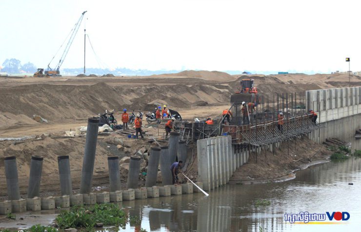បុរស​ម្នាក់​បោះ​សំណាញ់​នេសាទ​ក្នុង​ប្រឡាយ​ក្បែរ​ទីតាំងចាក់បំពេញដីនៃគម្រោងអភិវឌ្ឍន៍កោះនរា ក្នុង​ខណ្ឌ​ច្បារអំពៅ រាជធានី​ភ្នំពេញ កាល​ពី​ថ្ងៃ​ទី​៤ ខែ​វិច្ឆិកា ឆ្នាំ​២០២១។