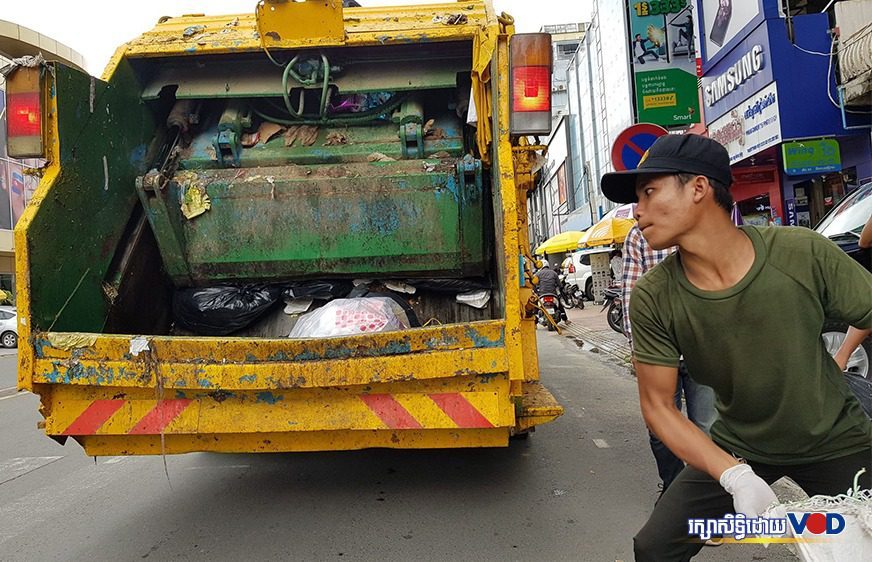 សន្តិសុខ​ខណ្ឌ​មួយ​រូប​កំពុង​បោះ​ស្បោង​សំរាម​ចូល​រថយន្ត ស្ថិតនៅ​តាម​បណ្តោយ​ផ្លូវ​ព្រះសីហនុ អំឡុង​កម្មករ​ប្រមូល​សំរាម​ក្រុមហ៊ុន ស៊ីន​ទ្រី ធ្វើកូដកម្ម​មិន​ចូល​ធ្វើការ នៅ​ថ្ងៃទី០៦ ខែតុលា ឆ្នាំ២០២០។ (ត្រាន់ តិច​សេង​)