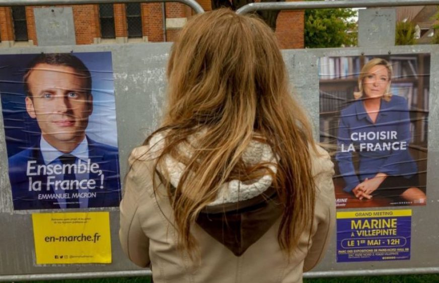 A woman looks at election campaign posters for French presidential election candidate for the far-right Front National (FN - National Front) party Marine Le Pen (R) and candidate for the En Marche ! movement Emmanuel Macron (L) on April 29, 2017 in Meteren, northern France.  / AFP PHOTO / PHILIPPE HUGUEN        (Photo credit should read PHILIPPE HUGUEN/AFP/Getty Images)