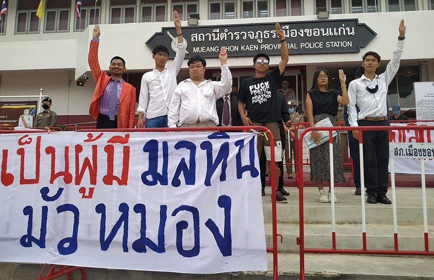 ក្រុមយុវជនឈរលើកម្រាមដៃបី នៅពីមុខប៉ុស្តិ៍ប៉ូលិសមួយនៅតំបន់ Khon Kaen ប្រទេសថៃ ថ្ងៃទី២១ ខែតុលា ឆ្នាំ២០២០។ (ហ្វេសប៊ុក៖ ศูนย์ทนายความเพื่อสิทธิมนุษยชน)