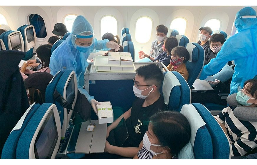 អ្នកបម្រើតាមយន្តហោះក្នុងសម្លៀកបំពាក់ការពារ បម្រើដល់ពលរដ្ឋវៀតណាមក្នុងការហោះហើរធ្វើមាតុភូមិនិវត្តន៍ពីប្រទេសជប៉ុន នៅថ្ងៃទី២២ ខែមេសា ឆ្នាំ២០២០។ (Vietnam Airlines/ VNExpress)