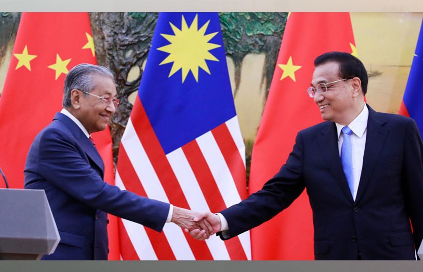 នាយករដ្ឋមន្ត្រីម៉ាឡេស៊ី មហាធា មហាមេដ (Mahathir Mohamad) (ឆ្វេង) ចាប់ដៃជាមួយលោក លី ឃឺឈាំង (Li Keqiang) នាយករដ្ឋមន្ត្រីចិន នៅចុងបញ្ចប់នៃសន្និសីទសារព័ត៌មានរួមគ្នារបស់ពួកគេនៅមហាសាលប្រជាជនប៉េកាំង នៅថ្ងៃទី20  ខែសីហា ឆ្នាំ2018 ។ រូបភាព៖ How Hwee Young | AFP | Getty Images