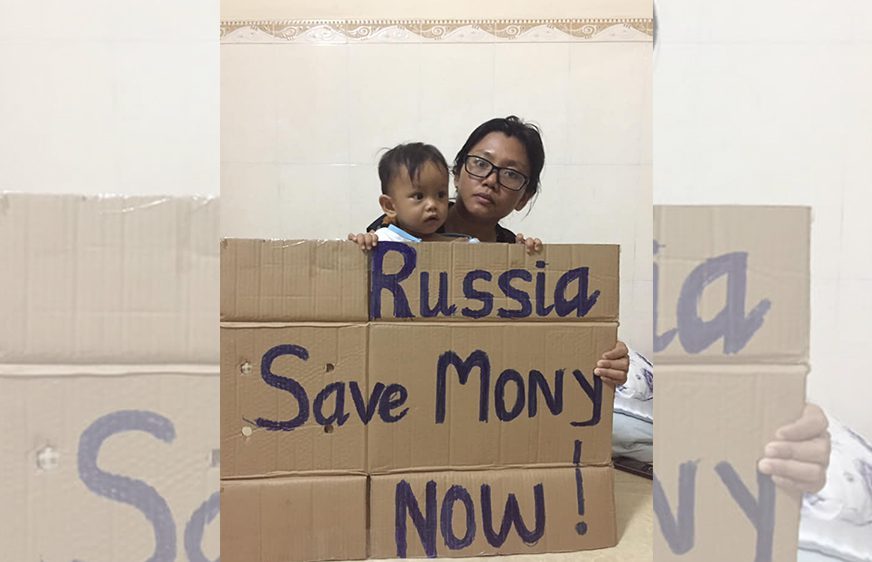 អ្នកស្រី ឡុង គឹមហ៊ាង និងកូនប្រុស កាន់បដាសរសេរពាក្យ Russia Save Mony Now! (រុស្ស៊ីជួយ មុនី ផងពេលនេះ)។ រូបភាព៖ ហ្វេសប៊ុក Long Kimheang